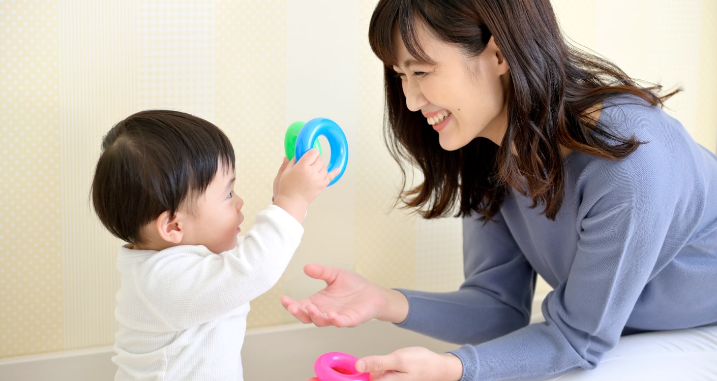小さな子どもと遊ぶ母親の写真